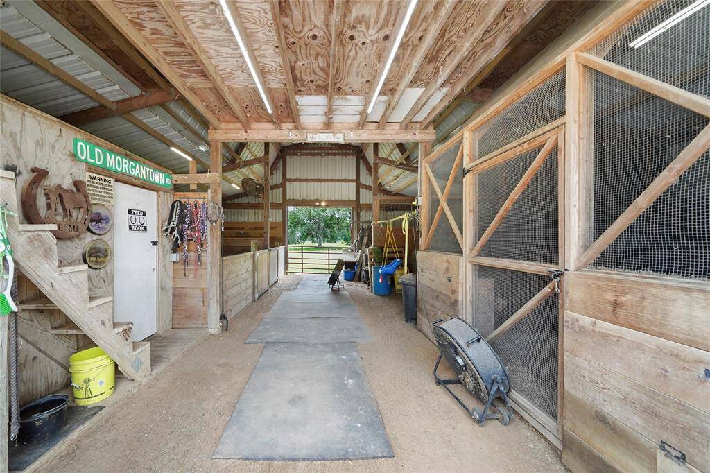 Inside the barn, well-maintained stalls ready for livestock or storage. Ample space for organizing tools, feed, and equipment, with easy access to the pastures.