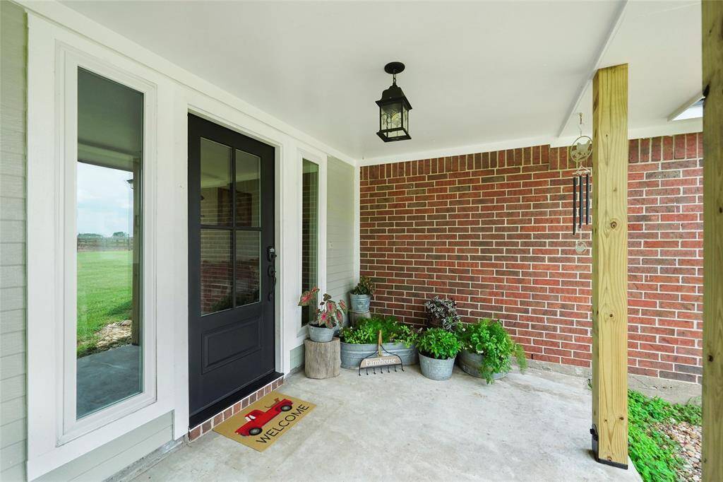 Inviting covered porch with fresh paint, updated light fixtures, and a keyless entry—offering charm and function right at the front door.