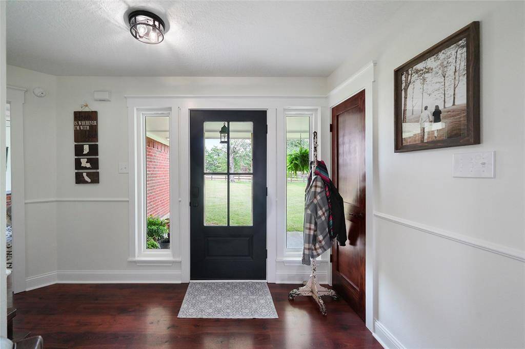 Fresh, inviting entry with rich flooring, updated light fixture, and keyless front door with sidelights—welcoming you home in style.