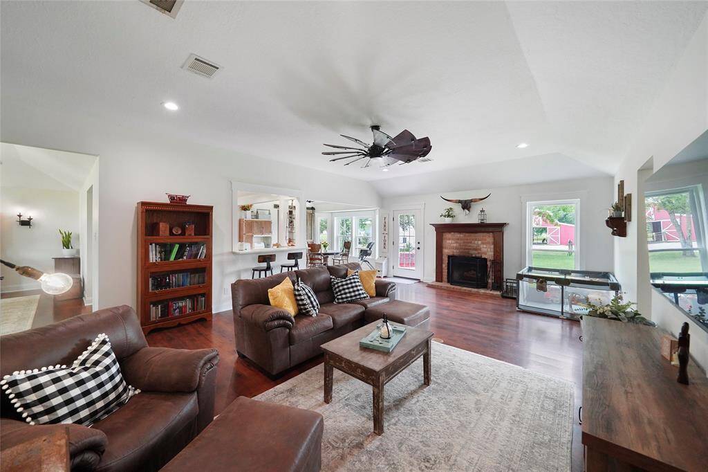 Spacious living area features a cozy wood-burning fireplace, laminate flooring throughout, and backyard views that bring in the light.