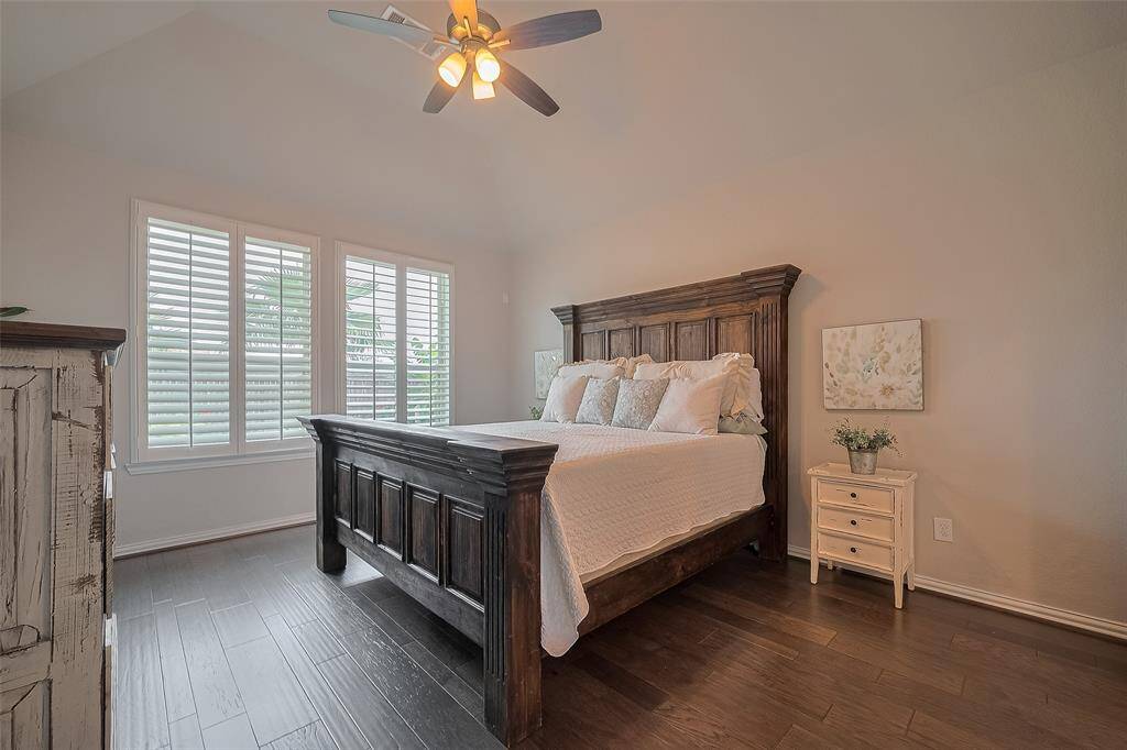 The primary suite, tucked away just off the family room, features the same warm wood floors and added privacy from classic Plantation shutters. The entire home is finished in neutral tones—move-in ready and waiting for you