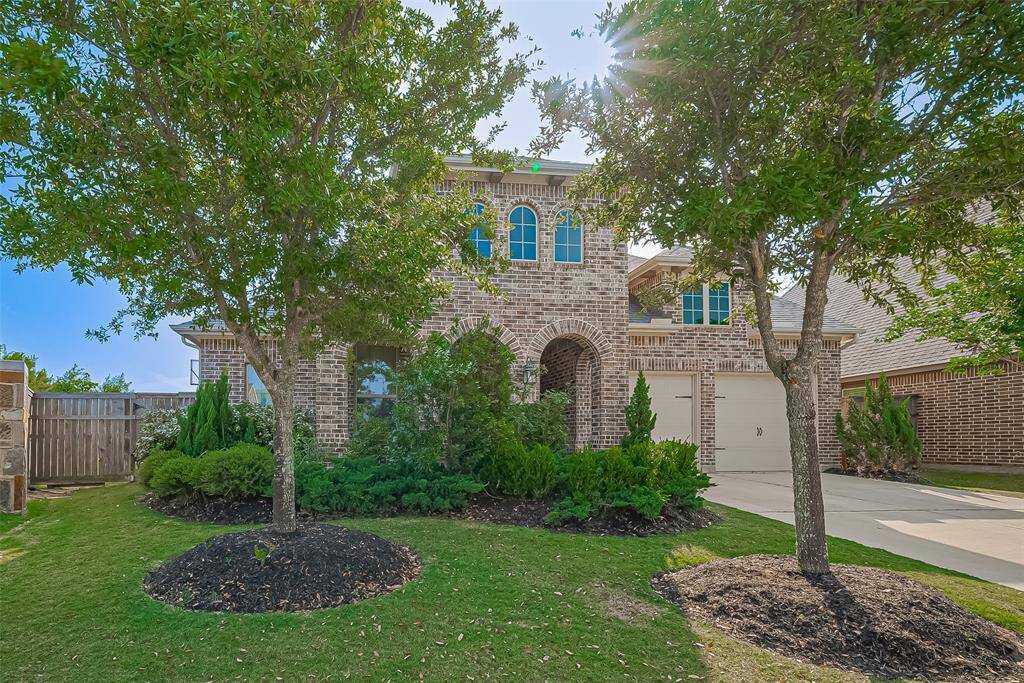 This home welcomes you with a charming covered front porch, mature trees, and beautifully landscaped yards—all effortlessly maintained with a convenient automatic sprinkler system.