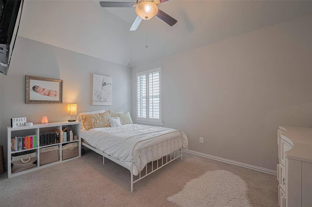 One of two upstairs secondary bedrooms, both featuring plantation shutters and ceiling fans—like all the bedrooms in the home