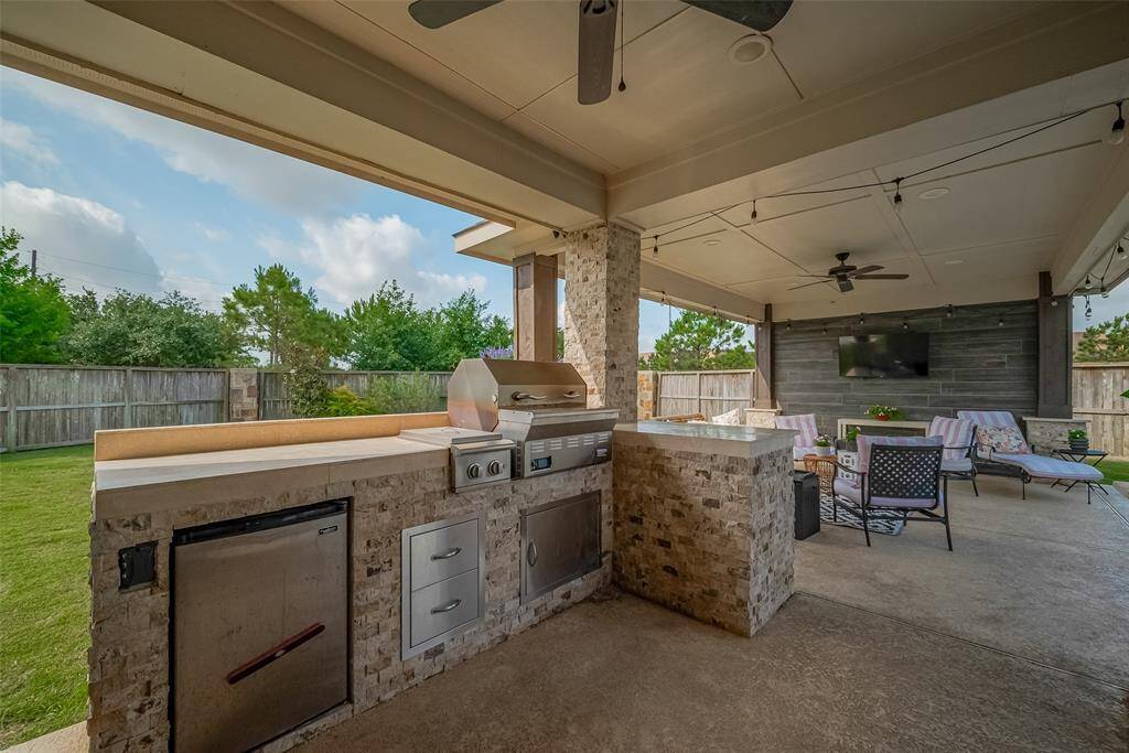 And now outside to your fantastic backyard!  The kitchen, covered patio & pool were installed in 2020.  The summer kitchen has a built-in Recteq pellet grill, gas burner cooktop, storage and mini refrigerator.