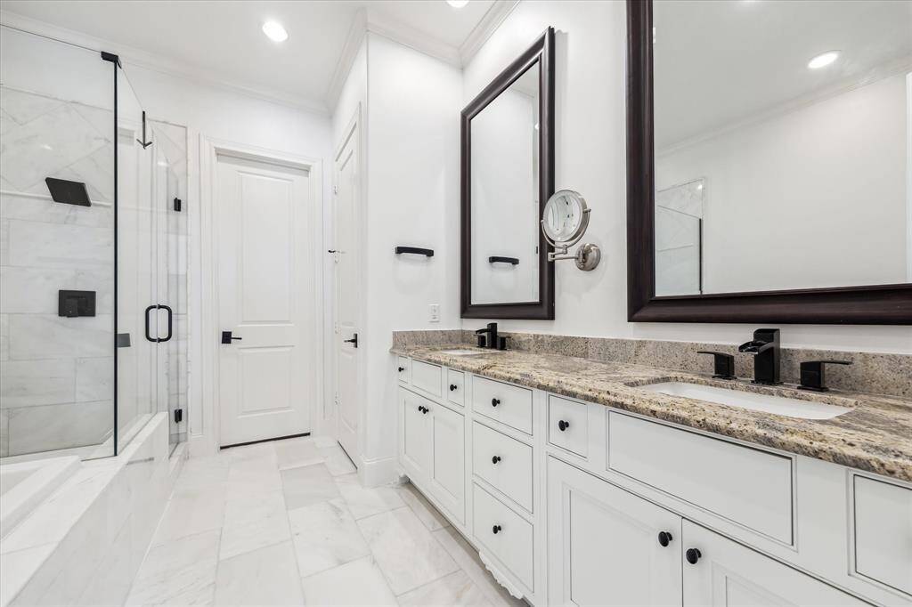 Walk-in closet with custom system, built-in storage, and full length mirror directly ahead. Private water closet with additional storage to the right.