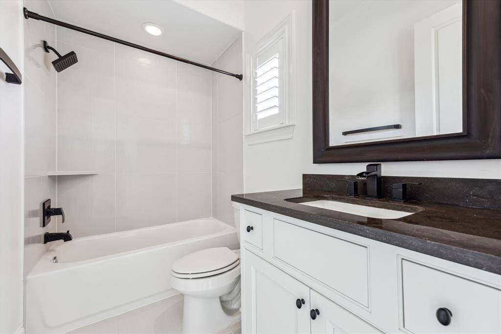 Limestone bathroom countertops with sleek shower/tub combo.