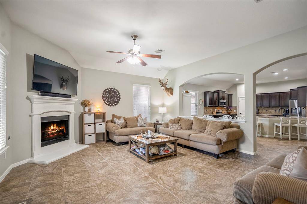 From the back door, enjoy a clear view through graceful arched openings into the dining area and kitchen—an open layout that still offers defined, inviting spaces.