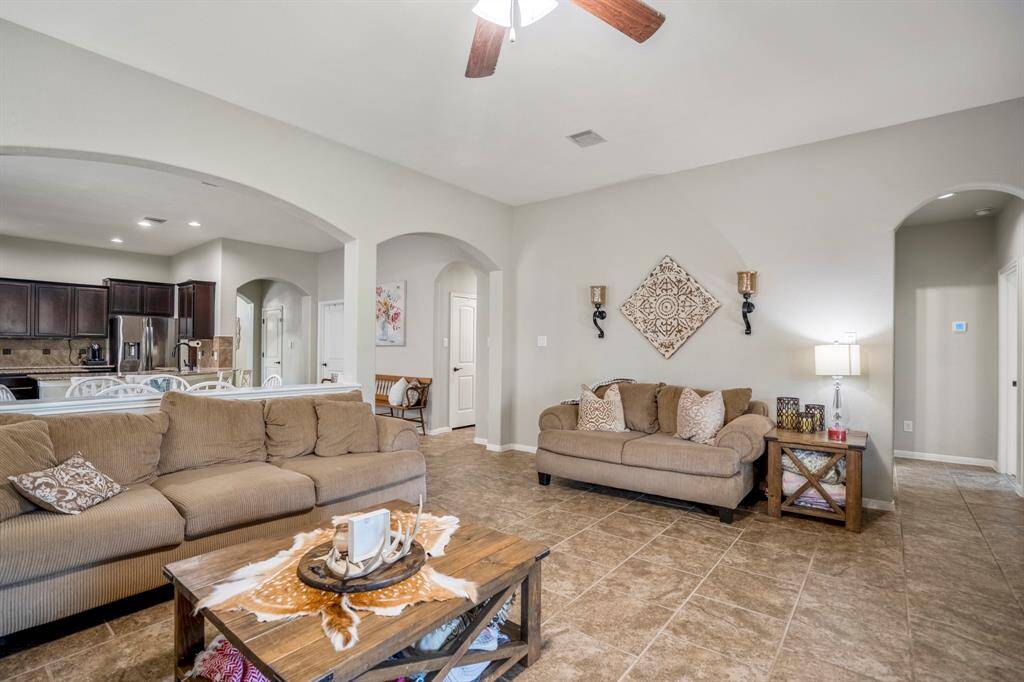 From the fireplace, you can see how the home opens up—dining and kitchen areas to the left, and both arched doorways ahead leading to separate bedroom hallways with a shared Jack-and-Jill bath in between.