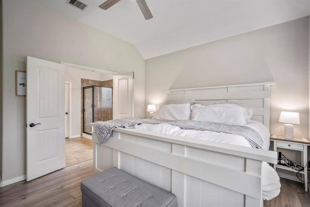 From the cozy bay window nook, glance back through the elegant double doors to the bright primary bathroom — a seamless flow that creates a calm, connected retreat just steps away.