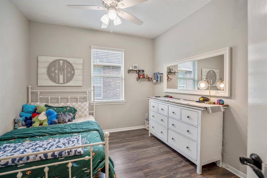 This bright third bedroom features easy-to-care-for vinyl plank floors and a large window that fills the space with natural light — a welcoming spot for rest or work.