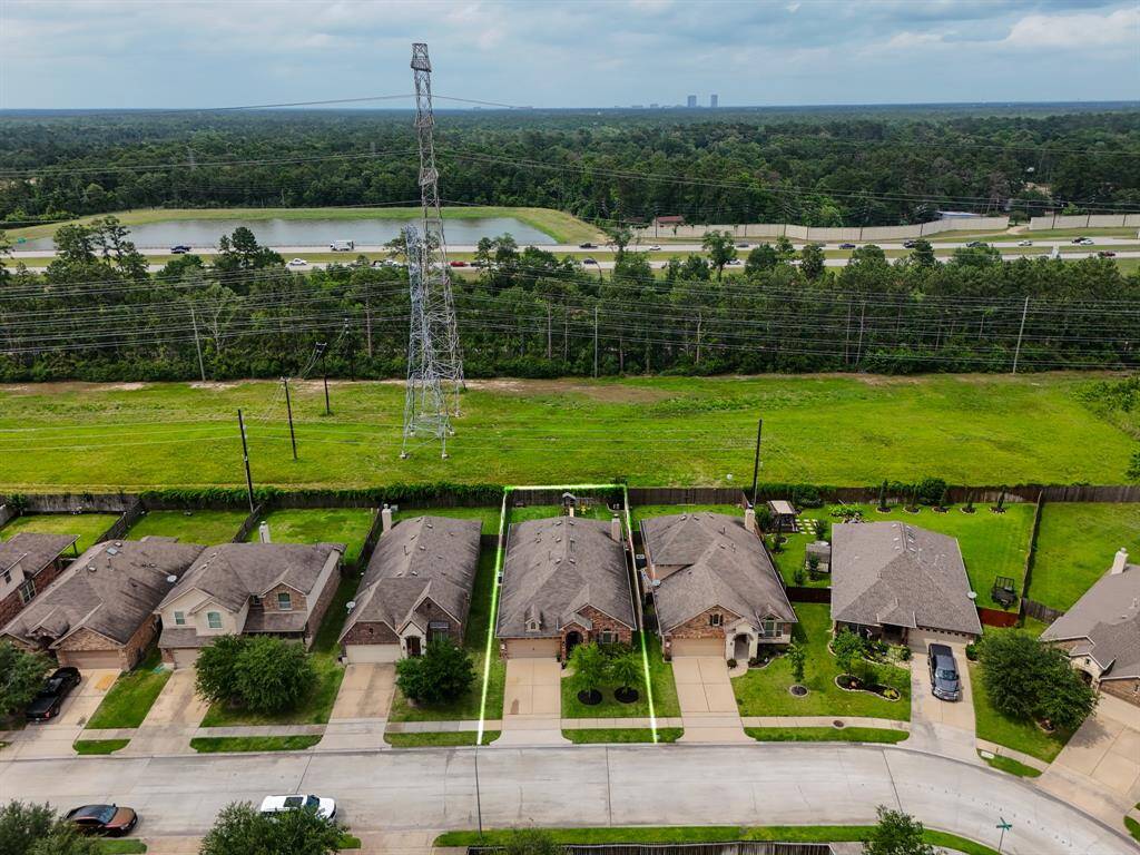 Aerial view showcasing the home’s peaceful setting with no rear neighbors and easy access to nearby Hwy 99—making your commute convenient while enjoying added privacy. In the distance you can see The Woodlands skyline, just minutes away!