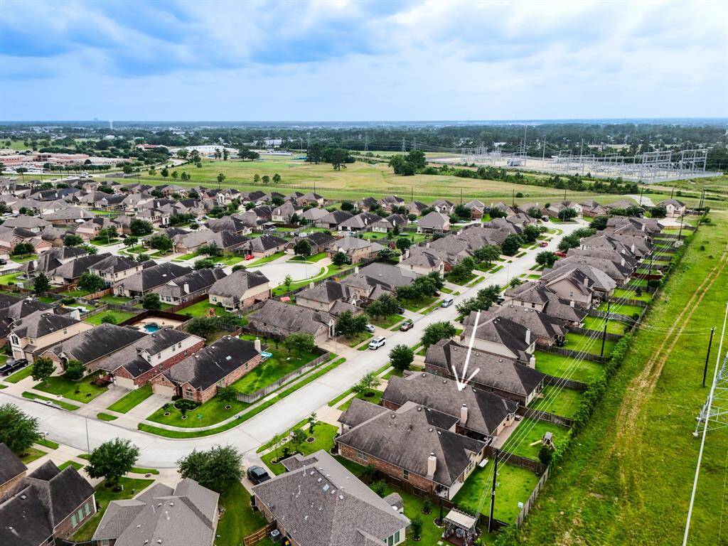This wider aerial captures the home’s prime location within the community, nestled alongside the greenbelt—offering both peaceful natural views and easy access to neighborhood trails and open spaces.