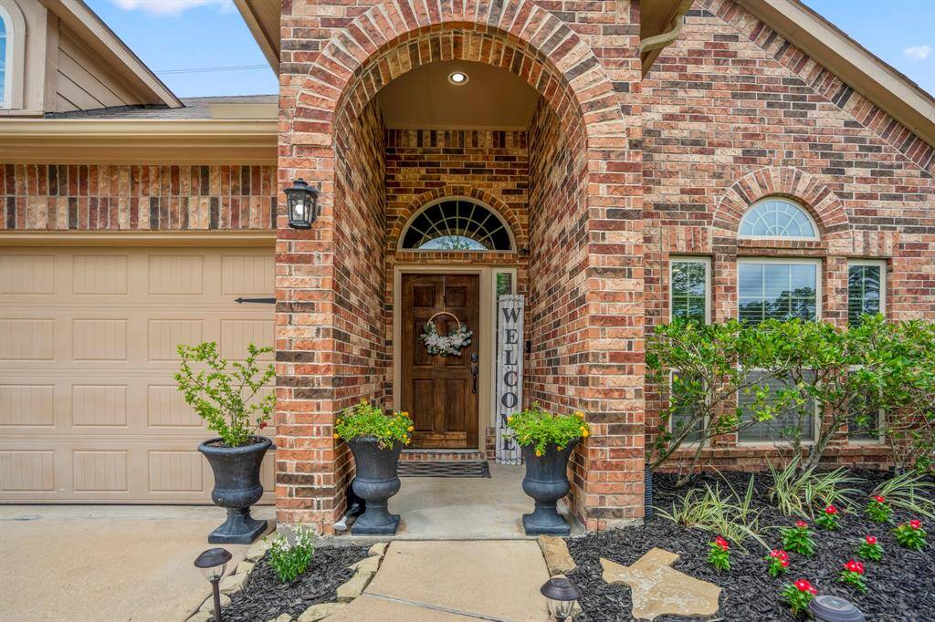 Step up to the front porch of your future home, where elegant arched brick details add character and a warm welcome.