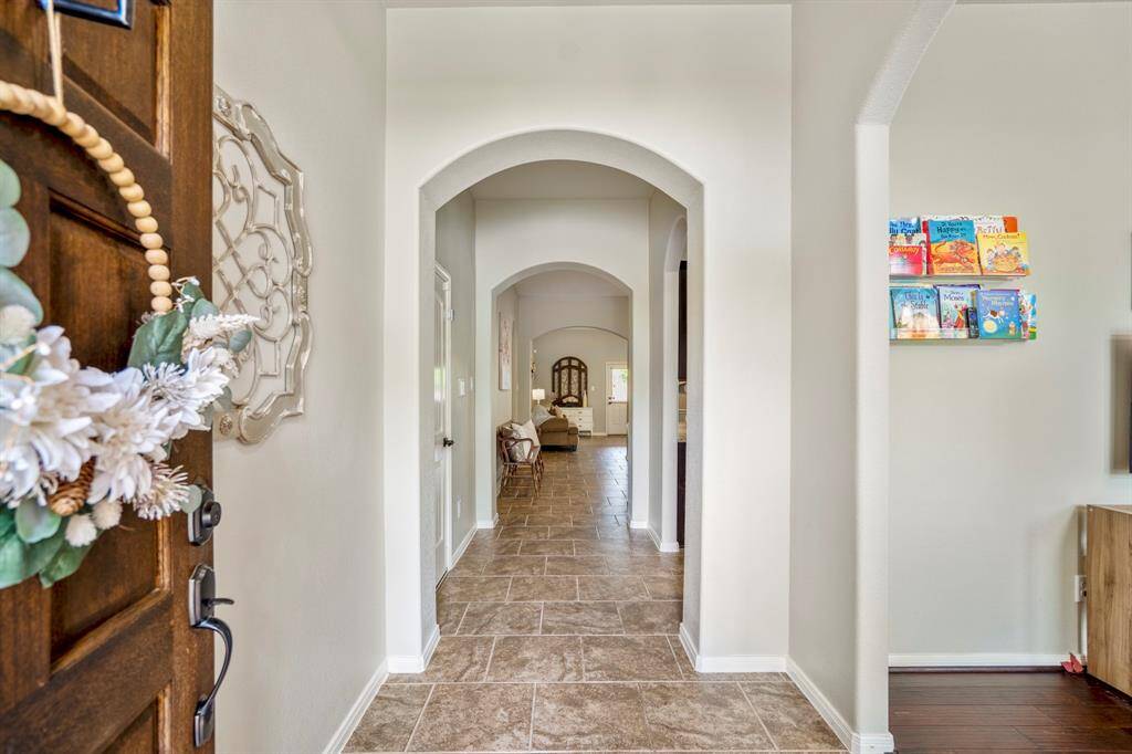 Step inside your future home and notice the arched opening to the right, welcoming you into a versatile space. Straight ahead, elegant arched doorways lead into the open living room and kitchen.