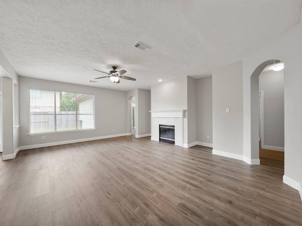 Step into a generously sized living area, the heart of this home, where a beautiful fireplace serves as the focal point. Bathed in natural light streaming through expansive windows, this space offers a warm and inviting ambiance, perfect for relaxation and entertaining.