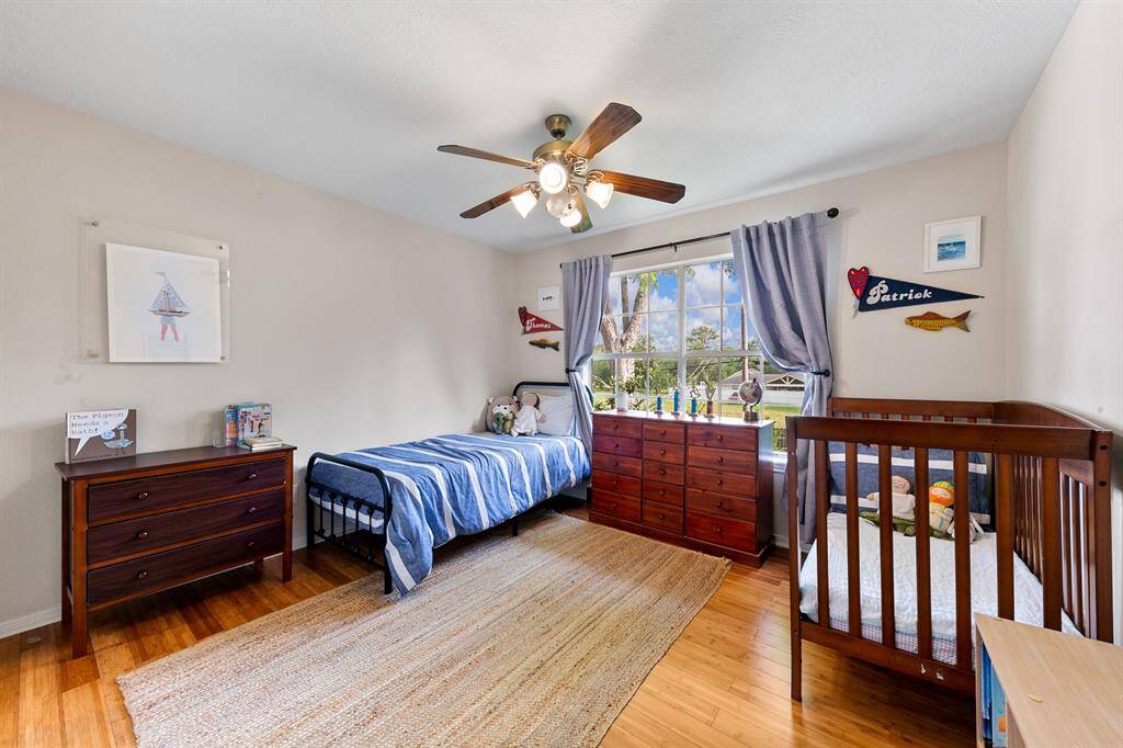 Set opposite the secondary bath with direct access, this large secondary bedroom highlights the peaceful views of the backyard and surrounding green space through a large picture window.