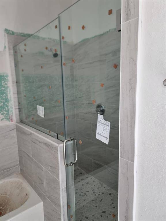Modern bathroom featuring a glass-enclosed shower with elegant tile work and a spacious design.