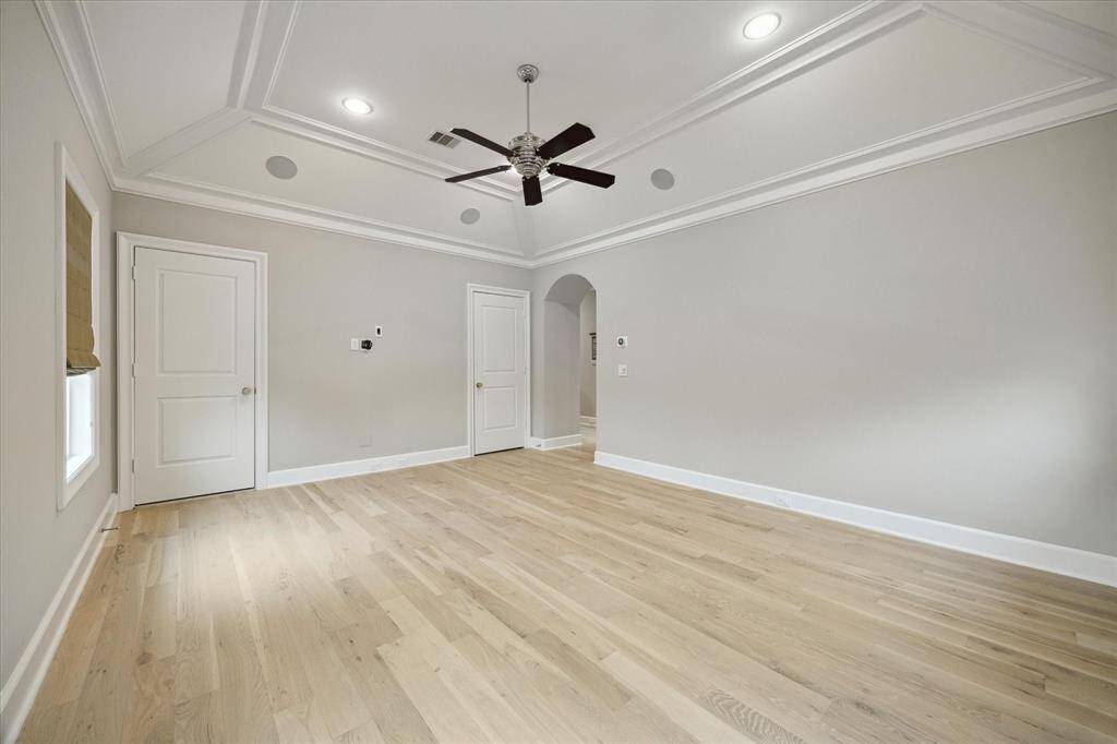 Large gameroom located upstairs features wood flooring, vaulted ceiling and door leading to third floor suite.