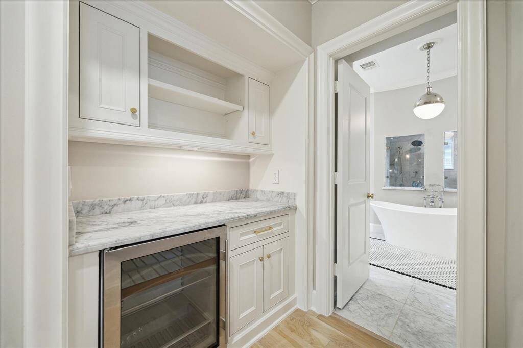 Dry bar in primary bedroom with beverage fridge allows for a convenient coffee bar.