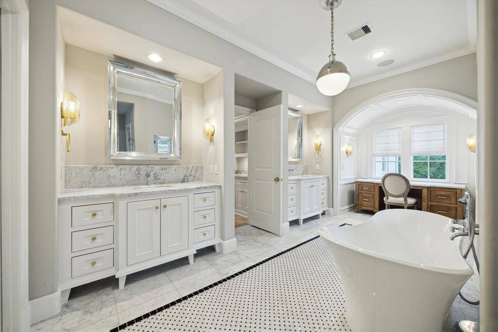 Massive primary bathroom offers dual vanities areas as will as additional vanity alcove.