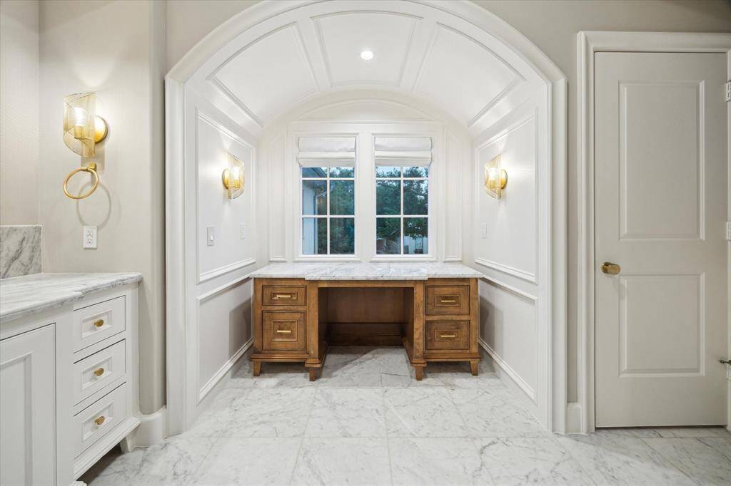 Elegant wood panel alcove with vanity area and sconces.