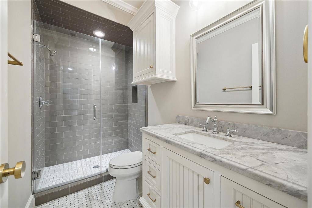 En-suite bathrooms showcase designer floor tiles that exude elegance, complemented by showers adorned with decorative tiles extending to the ceiling, creating a stunning visual impact. Frameless shower doors add a modern touch, while custom vanities provide both functionality and style.