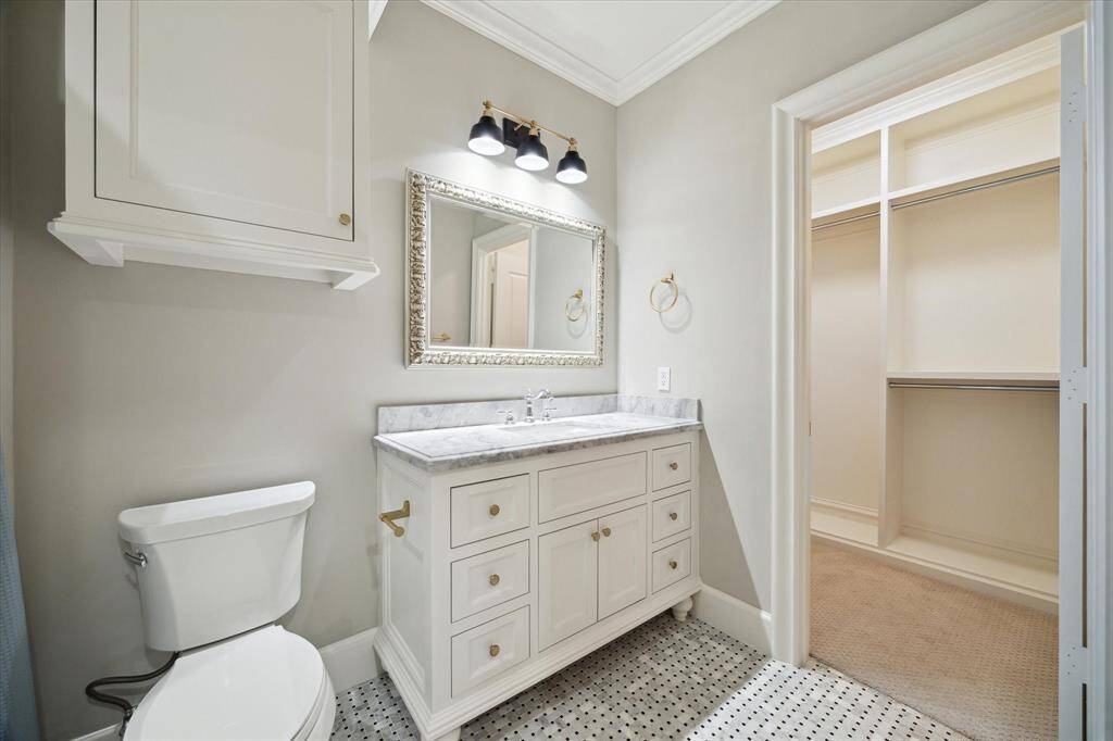 En-suite bathroom in bedroom that is currently set up as an additional closet or storage room.