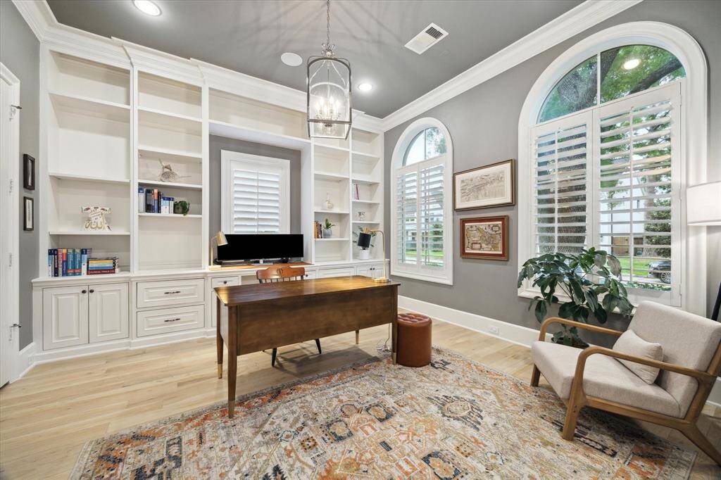 Discover a stylish study that exemplifies sophistication and functionality. This inviting space features elegant French doors that add a touch of charm while allowing natural light to flow in.
