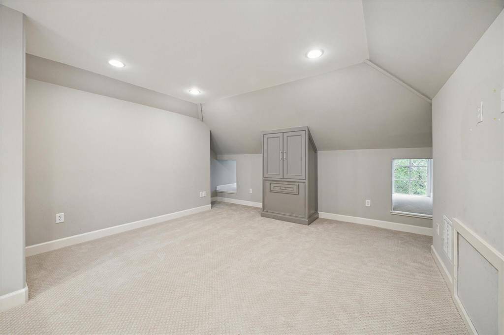 The third-floor bonus room offers a versatile space adorned with cozy Berber-style carpet, perfect for various uses.