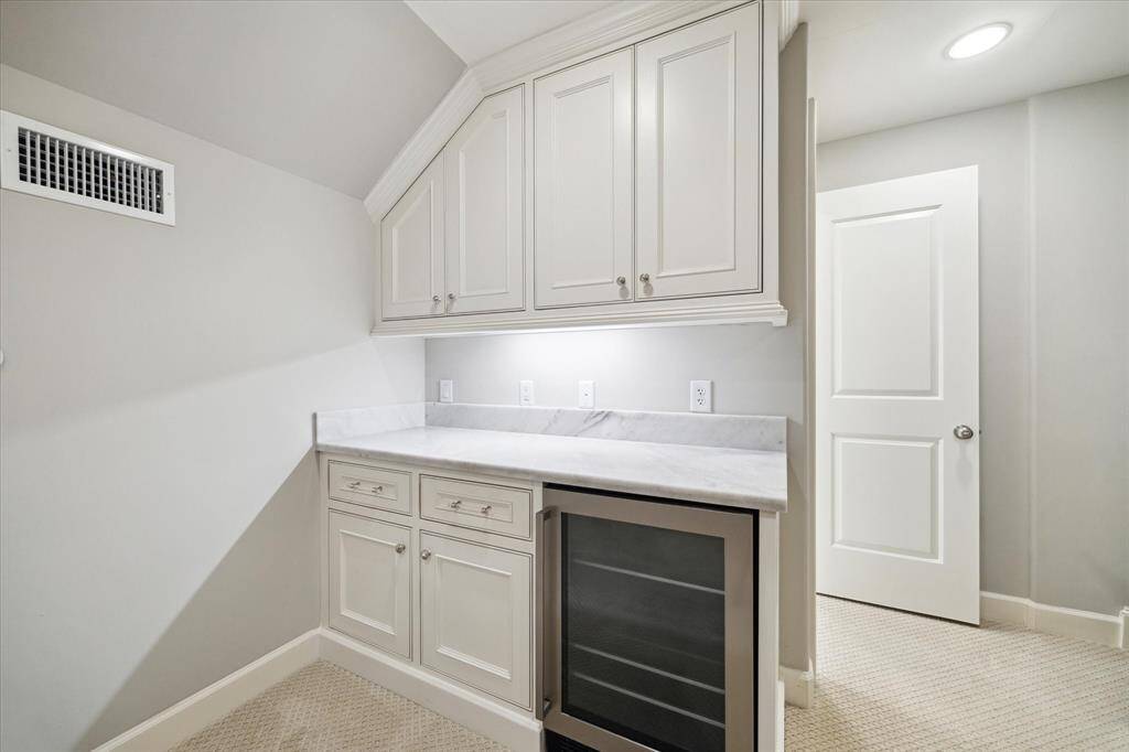 This flexible area includes a dry bar equipped with a beverage refrigerator for added convenience.