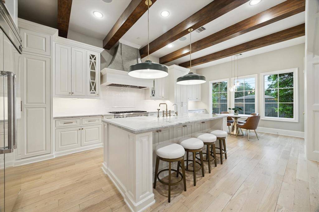 Stunning kitchen boasts Thermador appliances including a built-in fridge. Wood beam ceilings and on-trend finishes.