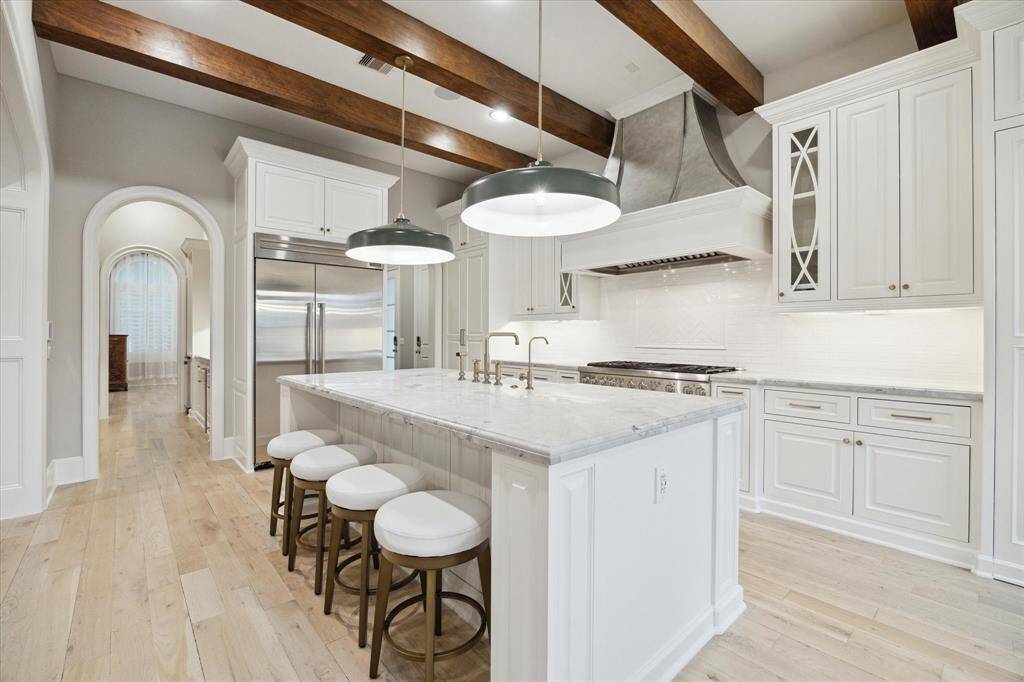 Another view of incredible kitchen highlighting large center island with counter height bar seating and an abundance of cabinetry.
