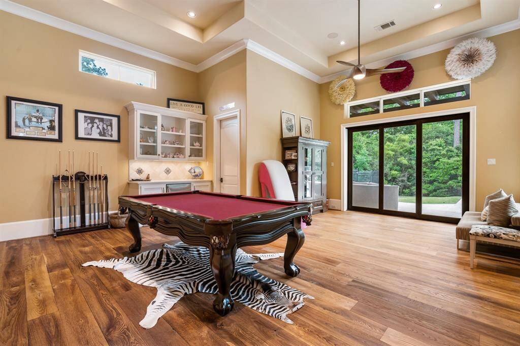 A first floor game room is complimented by warm wood flooring, built-in storage, full bath and enjoys sliding doors that open to the outdoor venues.