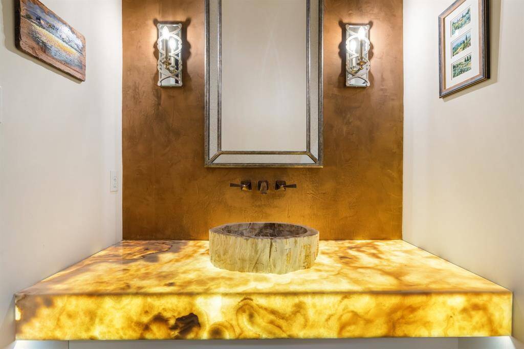 Guests are to appreciate this gorgeous guest powder room with lit onyx counter.