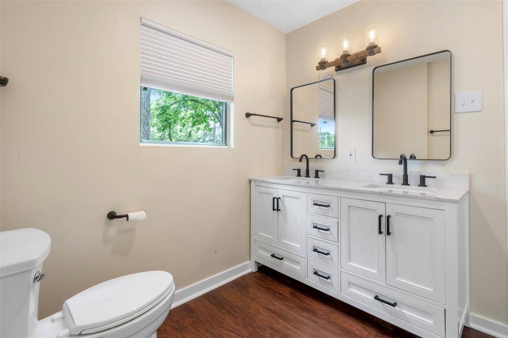 Bright bathroom with dual sinks and stylish mirrors, offering functionality with flair.