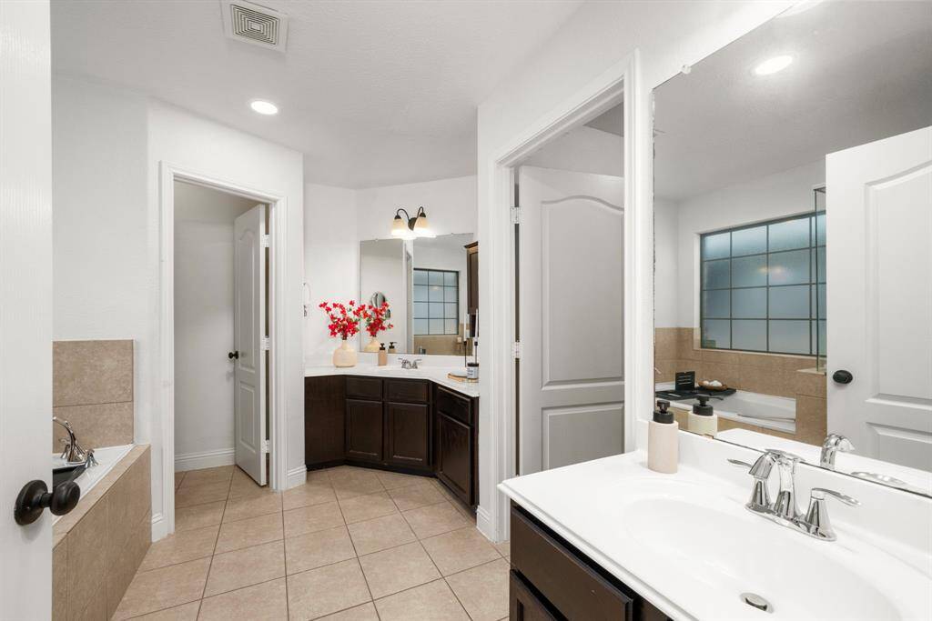 The Primary Bathroom offers dual vanity sinks (everyone loves to keep the peace at home, if possible!) and a separate soaking tub and shower.