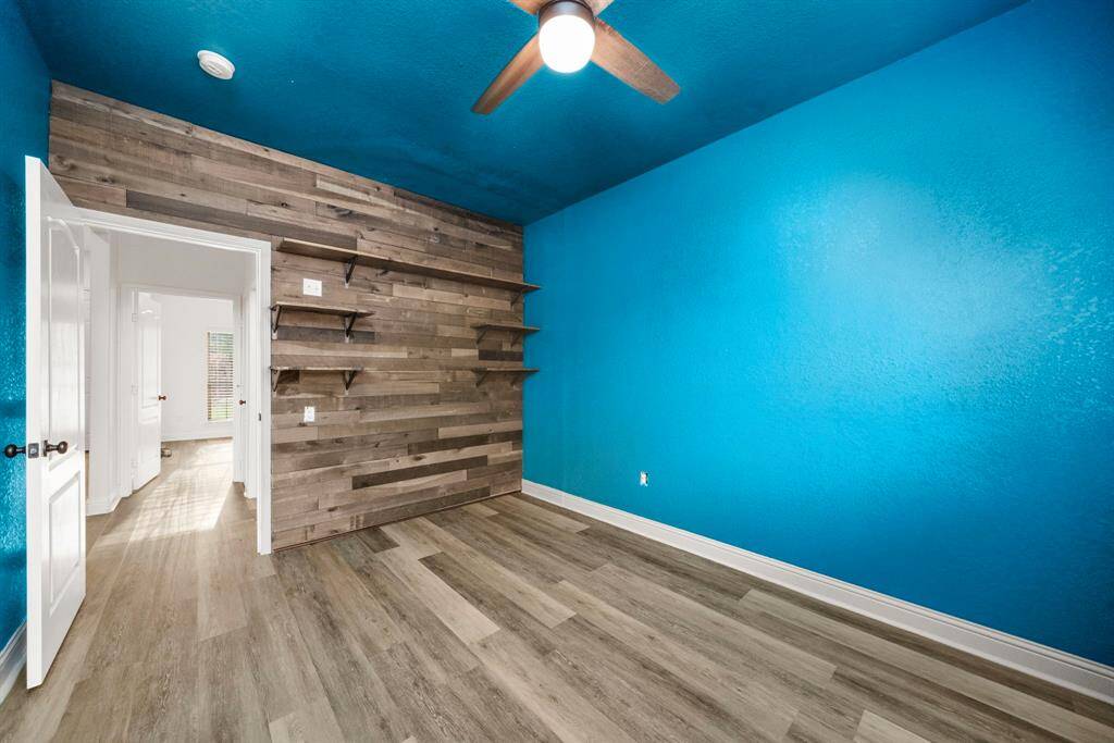 Welcome to the blue room! Previously used as a home brew and hobby room, this space could work great as a home office with a vice, workout space...or flex it back into a bedroom if needed. The hand paneled plank wall with built-in shelving worked perfectly for design inspiration.