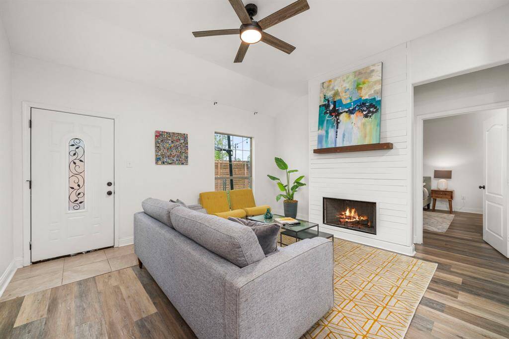 Alternate view showcasing the living with views onto the backyard. Doorway to the right leads to the primary bedroom. Door to the left leads to the backyard.