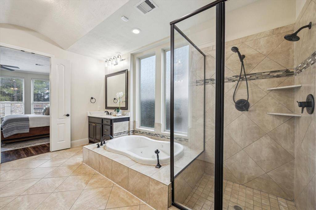 Beautiful quartz countertops, double sinks, large soaking tub, separate shower, vanity, and walk in closet with built ins