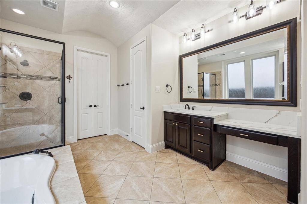 Large soaking tub, designer countertops and hardware, and resort style multi function separate shower with detachable handheld showerhead.