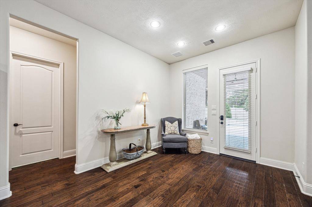 An elegant and cozy living with a gas log fireplace, and an abundance of natural light that illuminates the room with fabulous views of the backyard oasis.