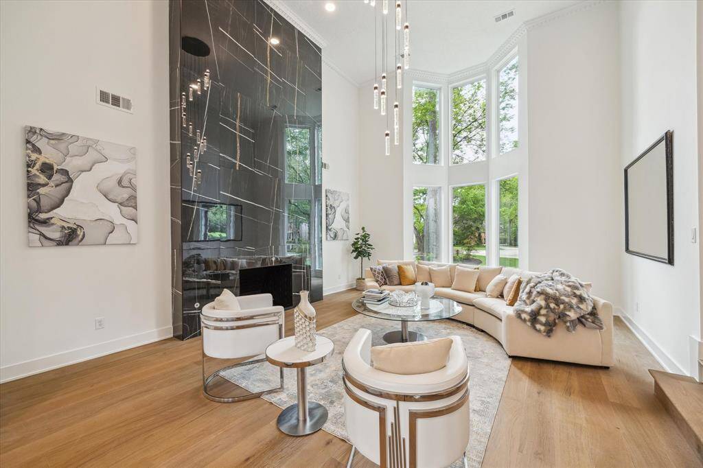 Sleek 20 foot black marble fireplace, and elegance invites you... The open space is enhanced by contemporary lighting and wood flooring, offering a stylish yet cozy atmosphere.