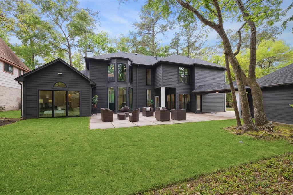 Showcasing a beautiful two-story home that has a spacious backyard patio area. The yard is well-maintained, surrounded by mature trees, offering a private and serene outdoor space.