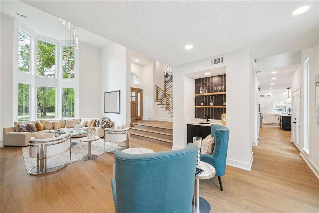 This stunning home features a spacious living area with floor-to-ceiling windows, offering scenic views.