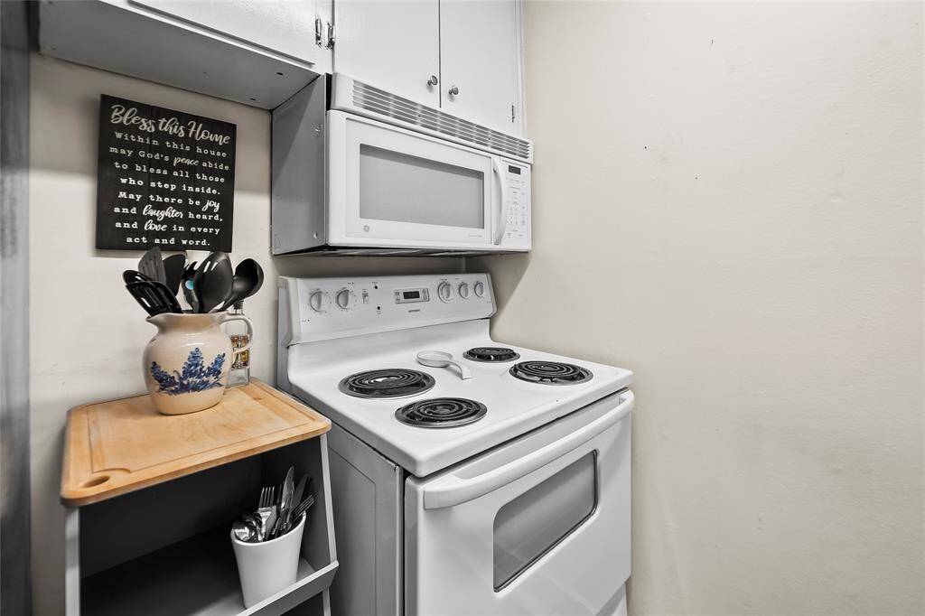 The kitchen features an electric stove, microwave, and dishwasher. The refrigerator conveys to the new buyers.