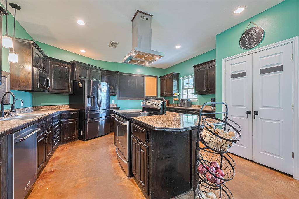 The island anchors the kitchen's efficient layout, surrounded by cabinetry and countertops that offer functionality from every angle.