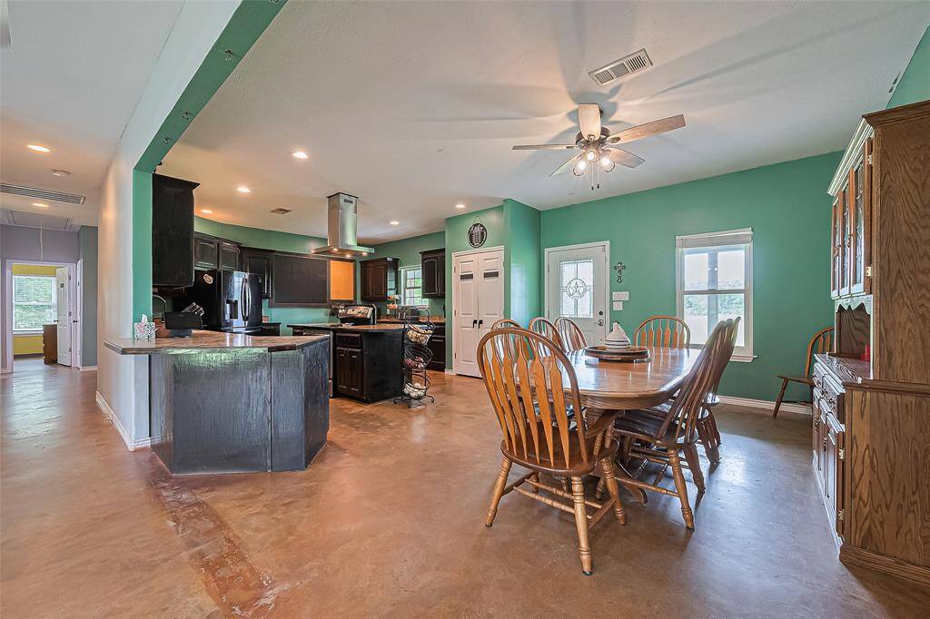 The dining space flows effortlessly from the kitchen, bathed in light from a large window and the glass-paned front door.