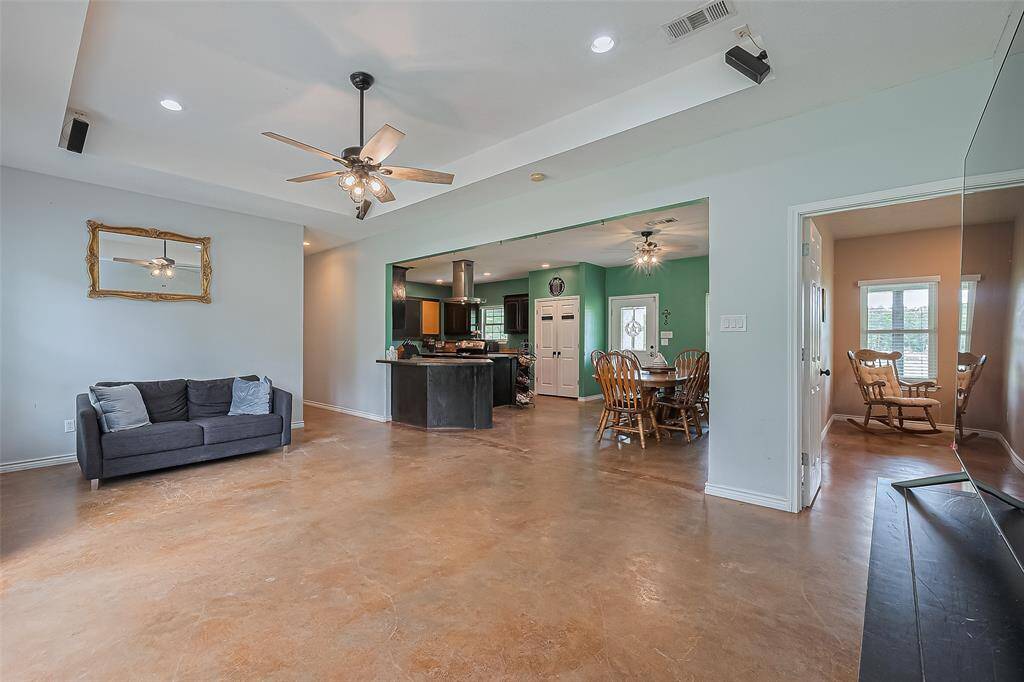 From the living room, you can see the kitchen and dining areas and the nearby primary bedroom—designed for connection and convenience.