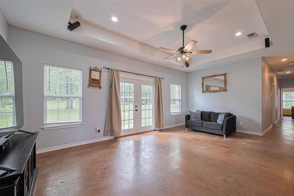 Abundant sunlight filters through large windows and French doors, opening to the backyard and filling the living room with an airy feel.