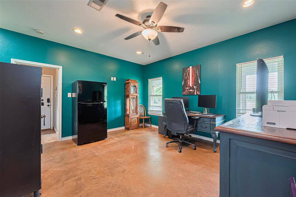 Ceiling fan, recessed lights, and large windows ensure the office remains bright and comfortable throughout the day.